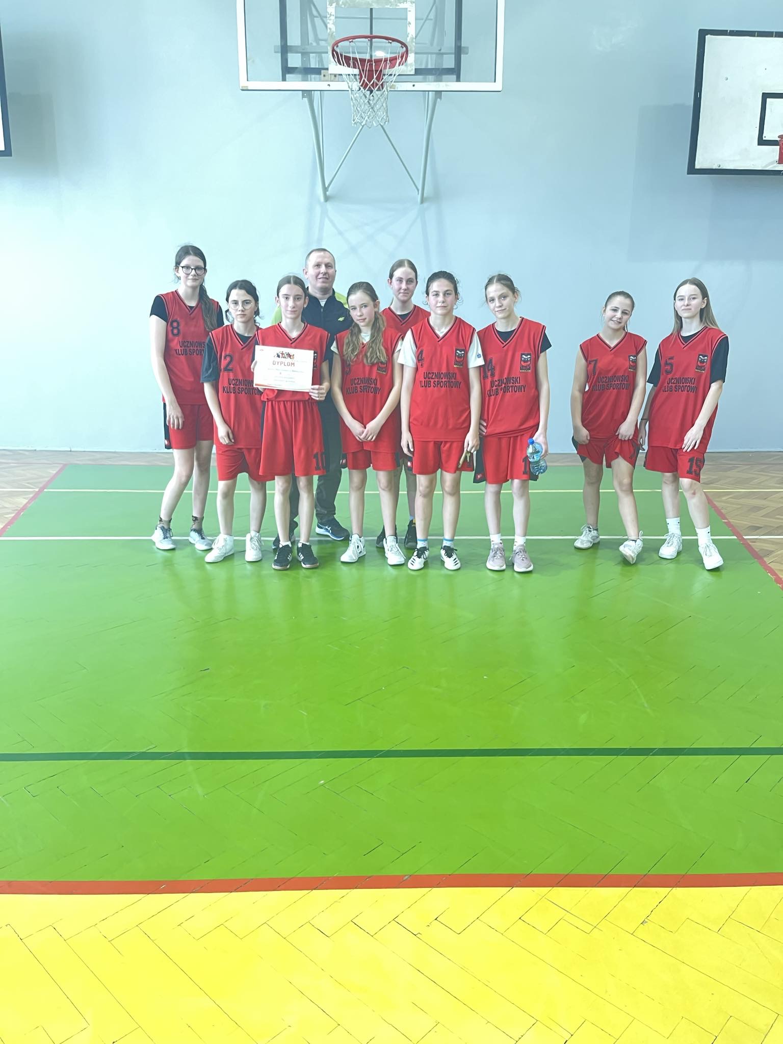 Zdjęcie drużyny dziewcząt ze Szkoły Podstawowej im. H. Sienkiewicza w Bobolicach podczas półfinałów województwa w koszykówce